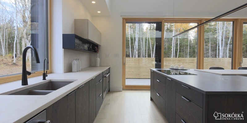 Nowoczesna kuchnia z wyspą i dużymi oknami tarasowymi