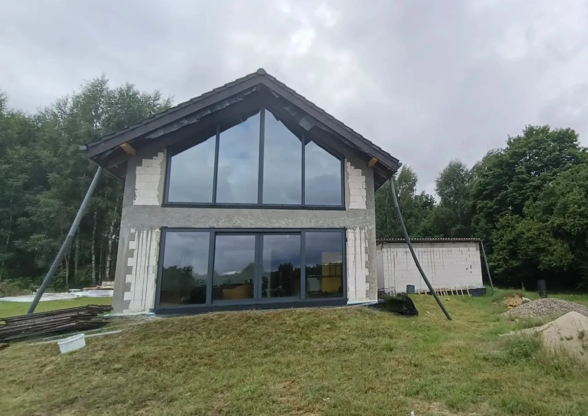 Widok na nowo zamontowane okna wielkoformatowe w elewacji domu jednorodzinnego na budowie