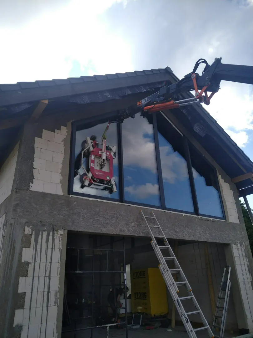 Montaż okien wielkoformatowych na elewacji domu przy użyciu chwytaka próżniowego