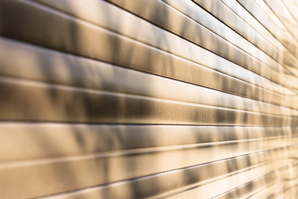 Poziome stalowe panele bramy garażowej z cieniami drzew