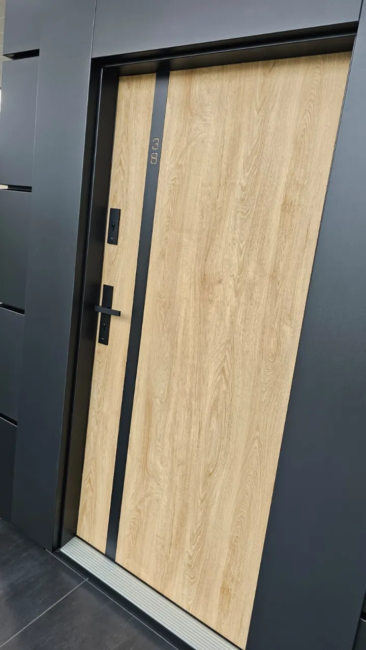 Nowoczesne drzwi wejściowe z drewnianą powierzchnią i czarną aluminiową ramą z zamkiem elektronicznym