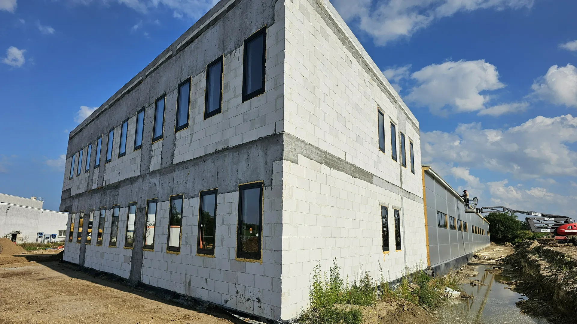 Dwukondygnacyjny budynek w budowie z zamontowanymi oknami PCV podczas montażu okien