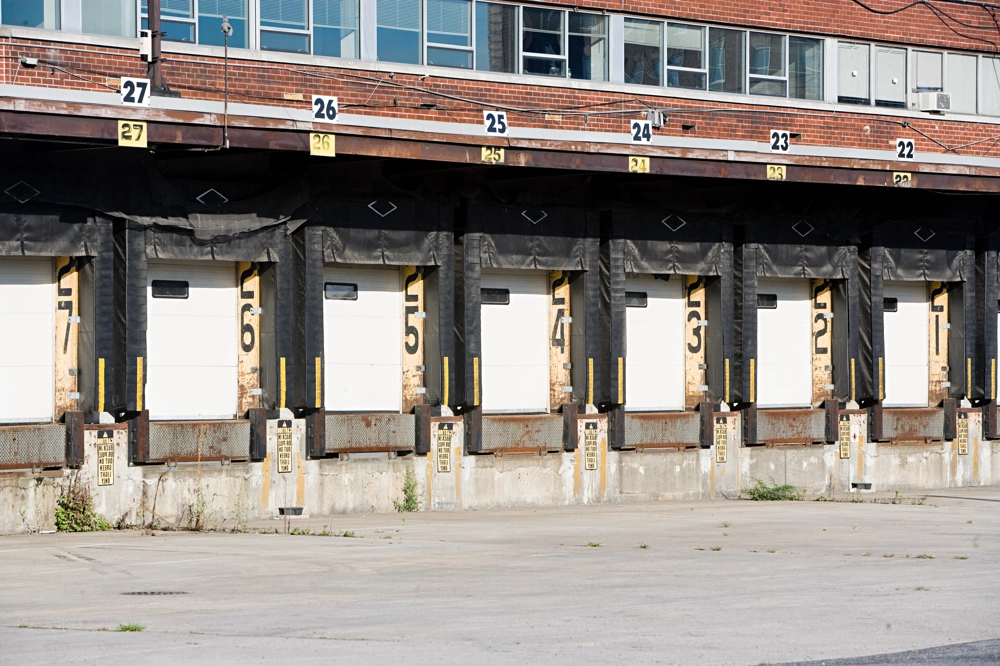 Doki przeładunkowe przy magazynie z wieloma zamkniętymi bramami, systemy przeładunkowe