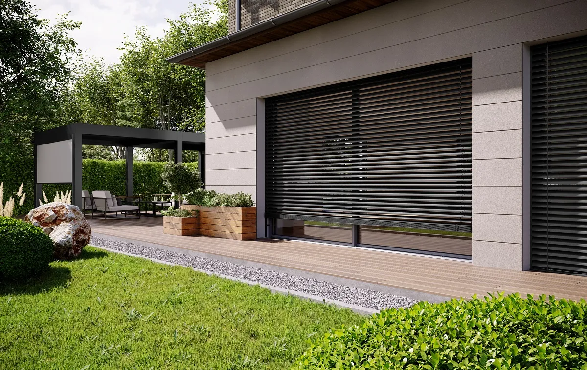 Elewacja budynku z dużym przeszkleniem tarasowym osłoniętym żaluzjami fasadowymi i drewnianym tarasem