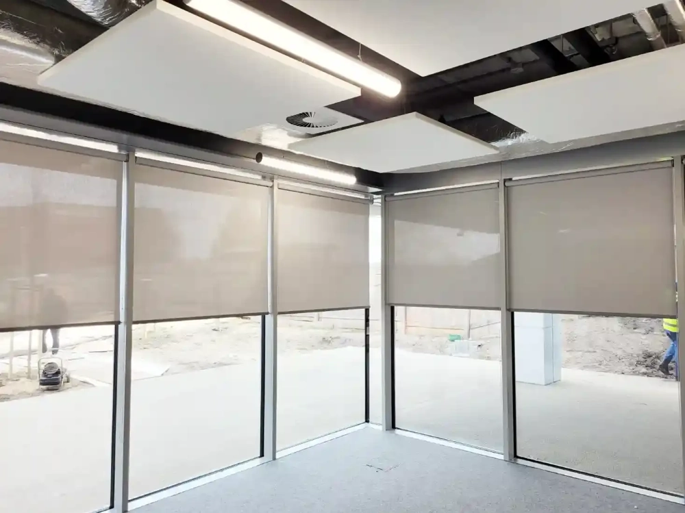 Wnętrze z wielkoformatowymi oknami i opuszczonymi roletami screen