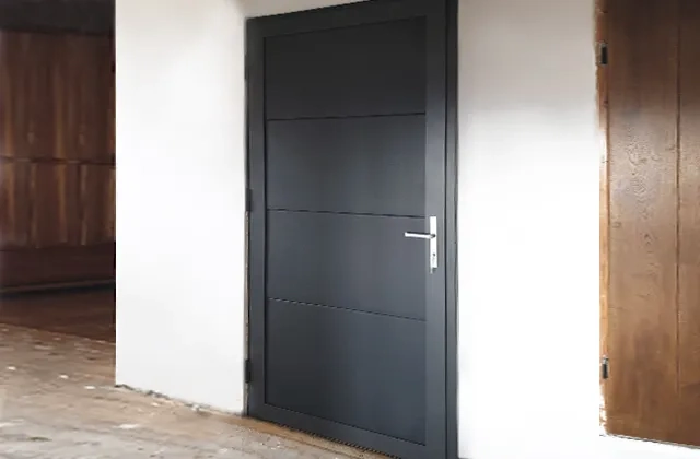 Czarne drzwi wejściowe zamontowane w ścianie podczas montażu drzwi