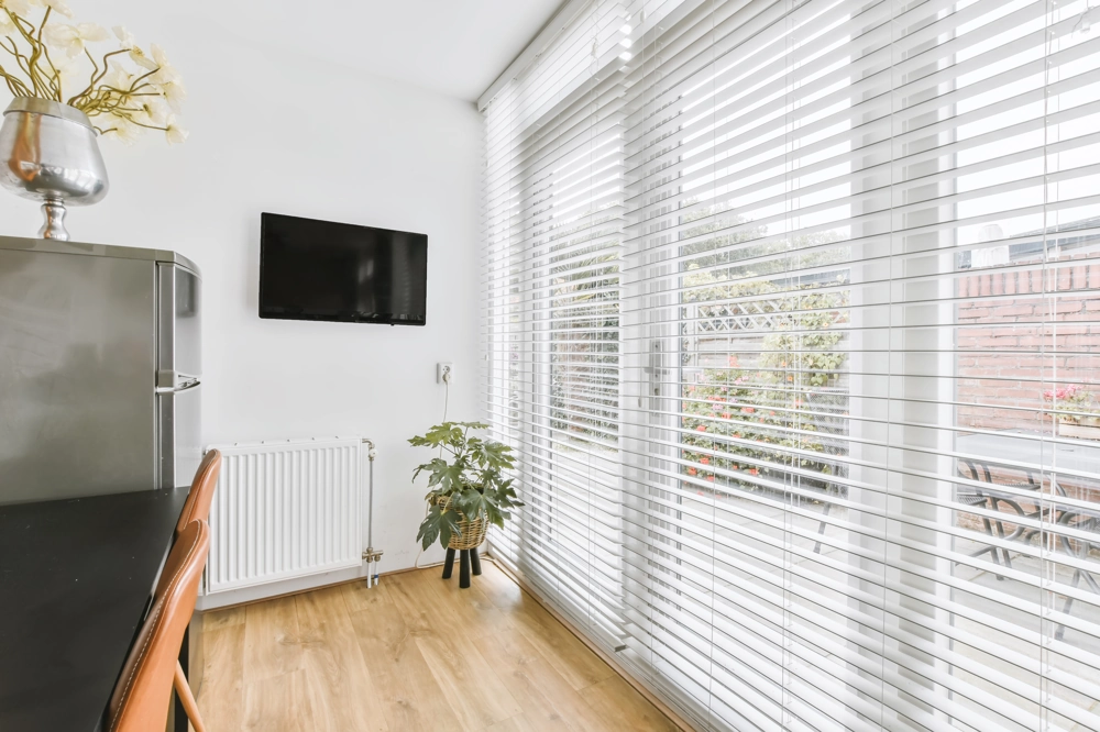 Okna tarasowe z żaluzjami fasadowymi w jasnym wnętrzu